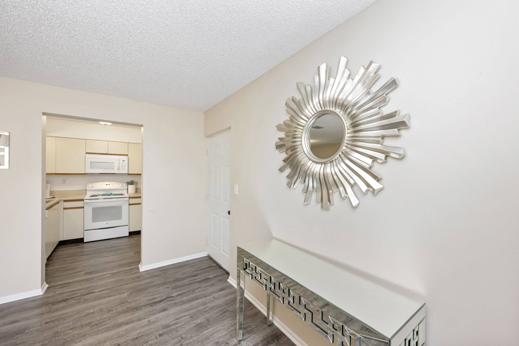 a living room with a table and a kitchen in the background