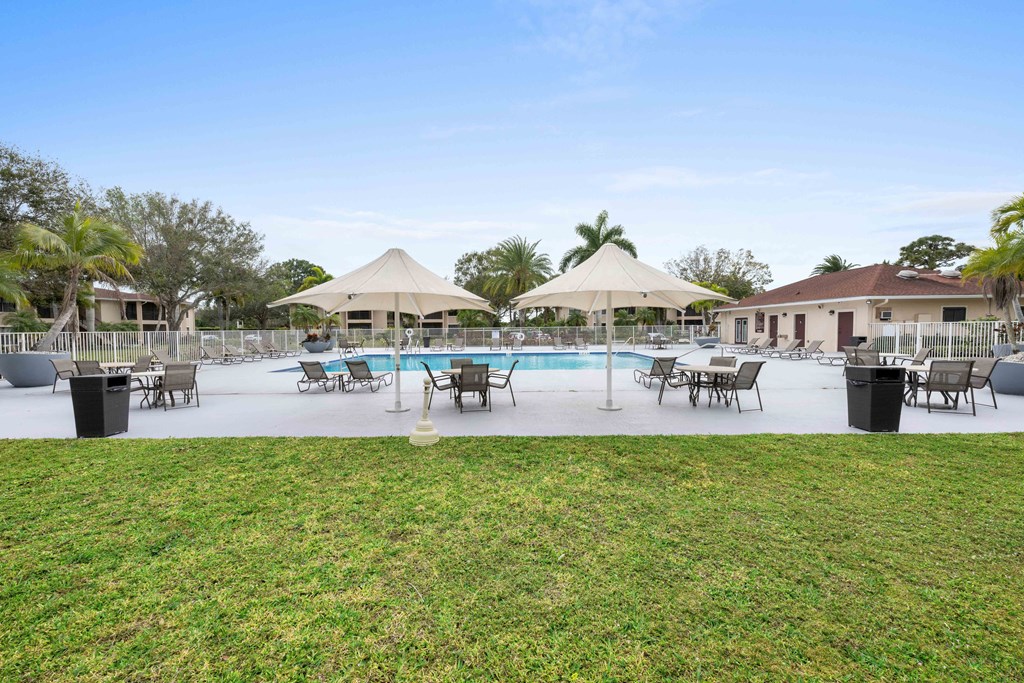 a swimming pool with umbrellas and chairs around it