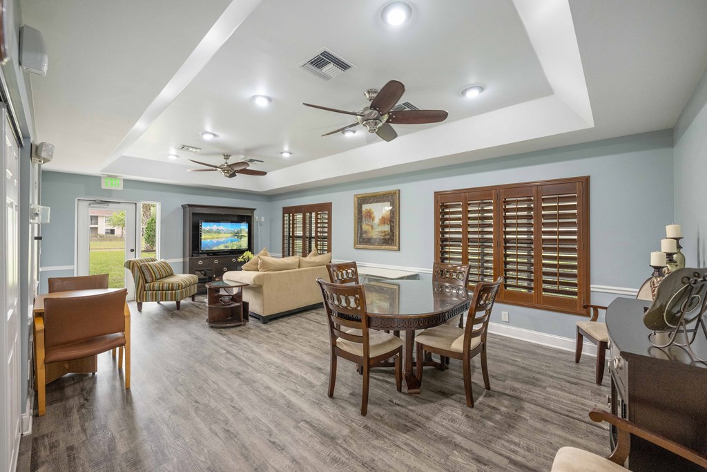 a living room and dining room with blue walls and a coffered ceiling