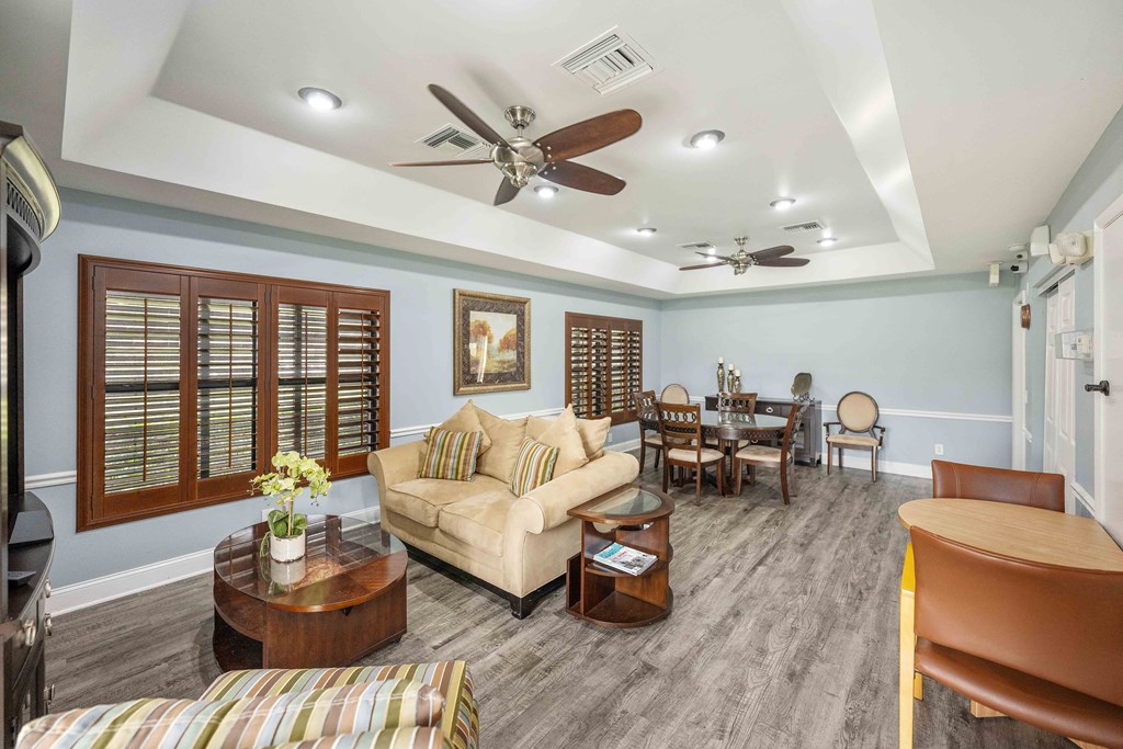 a living room with a couch a table and a ceiling fan
