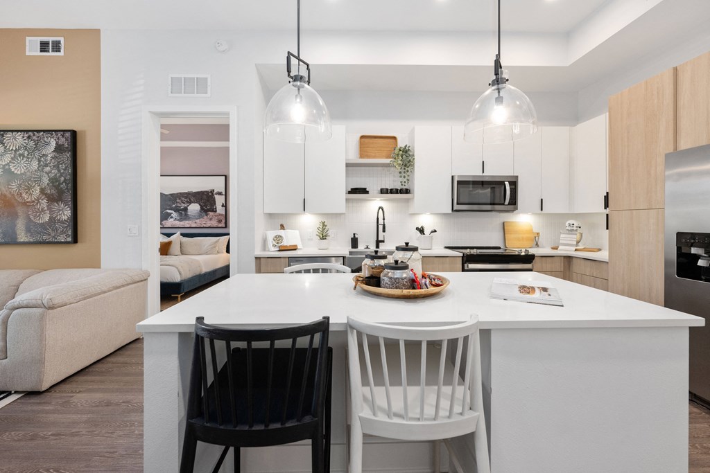 an open kitchen with a large island with two chairs
