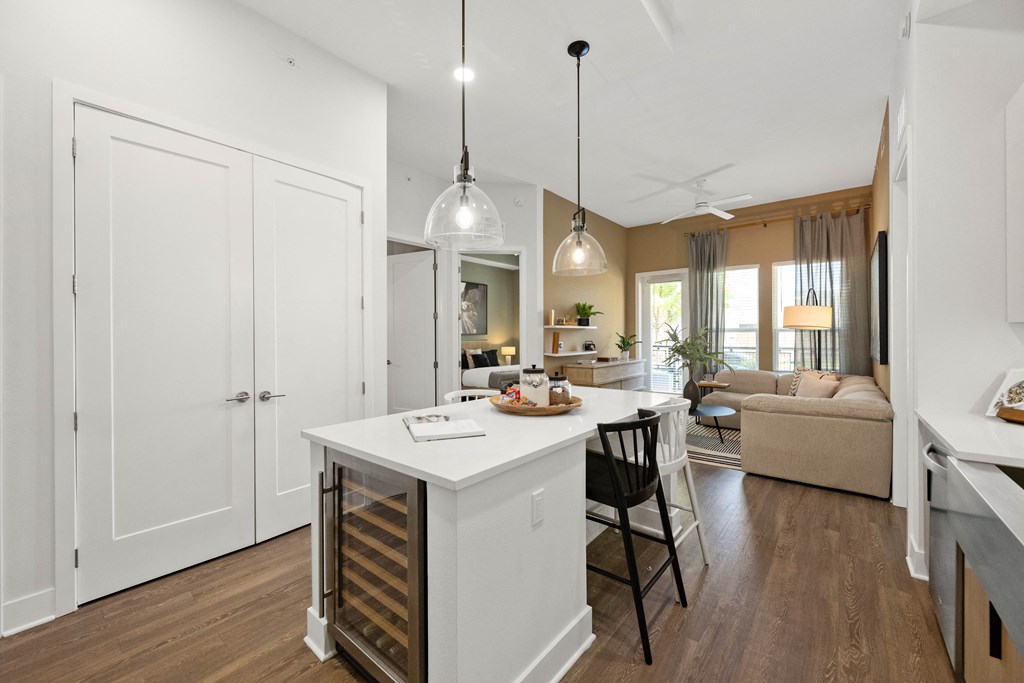 a kitchen and living room with white cabinets and a white counter top