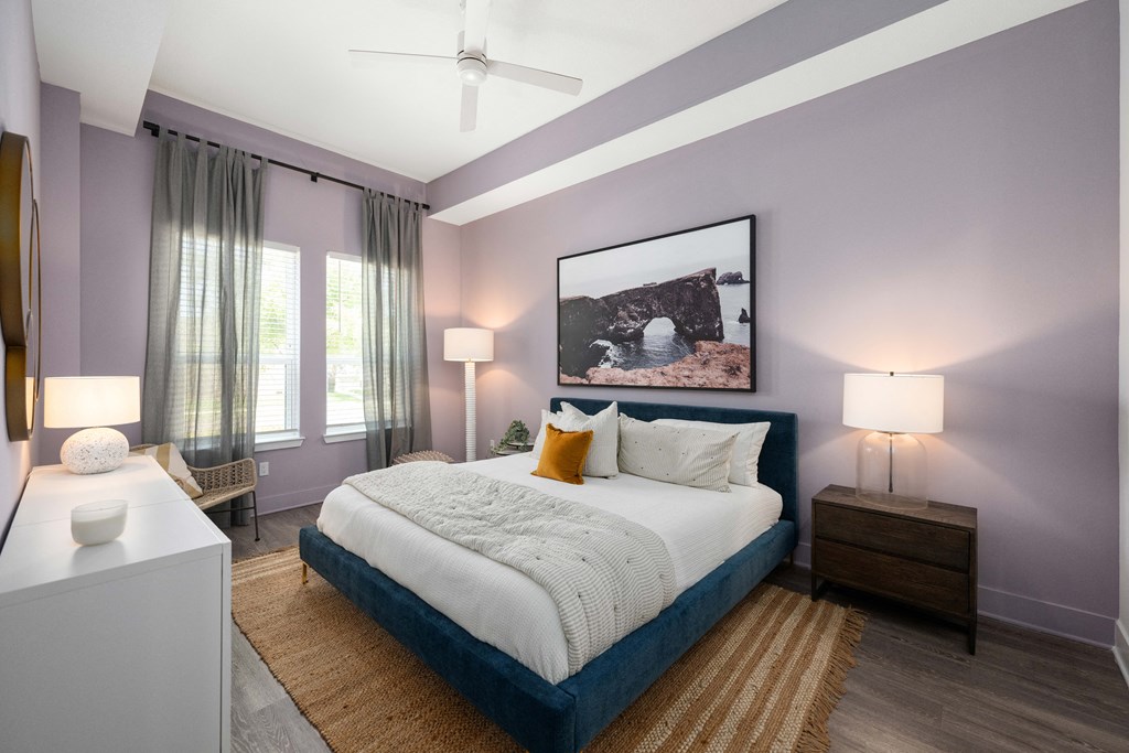 a bedroom with purple walls and a white bed
