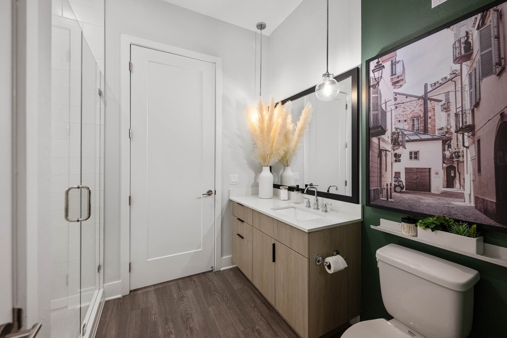 a bathroom with a toilet sink and mirror and a shower