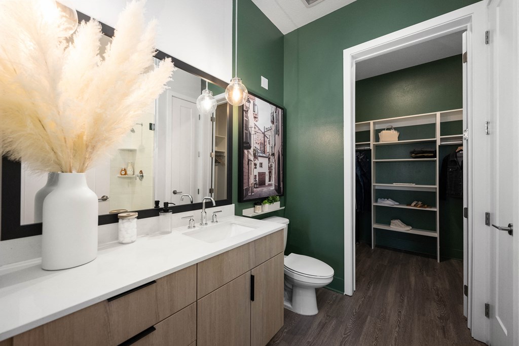 a bathroom with green walls and a white counter top and a toilet