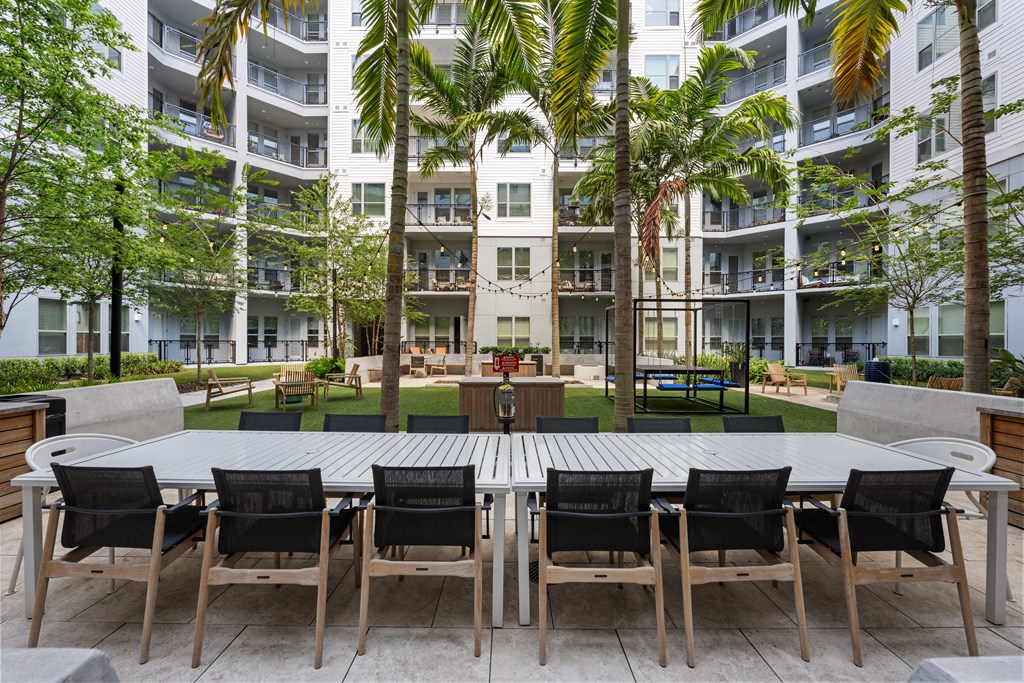 a large table and chairs in a courtyard at an apartment building