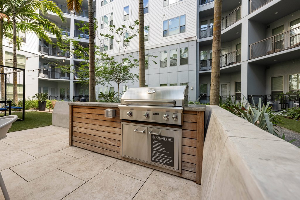 a barbecue grill on a patio in front of an apartment building