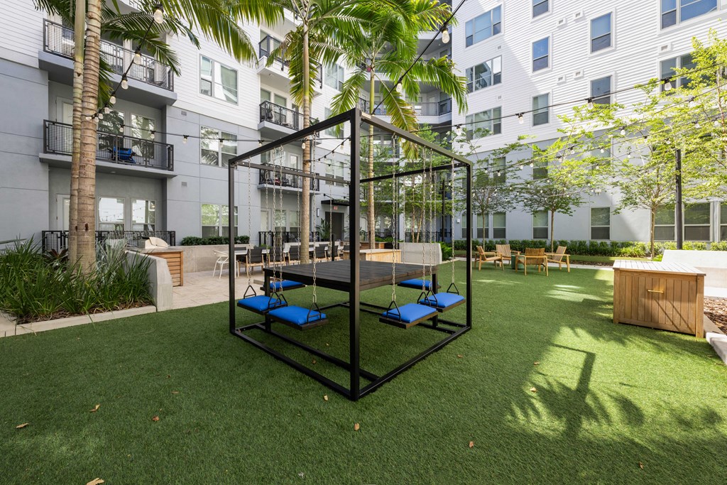 a playground with blue lounge chairs in a courtyard