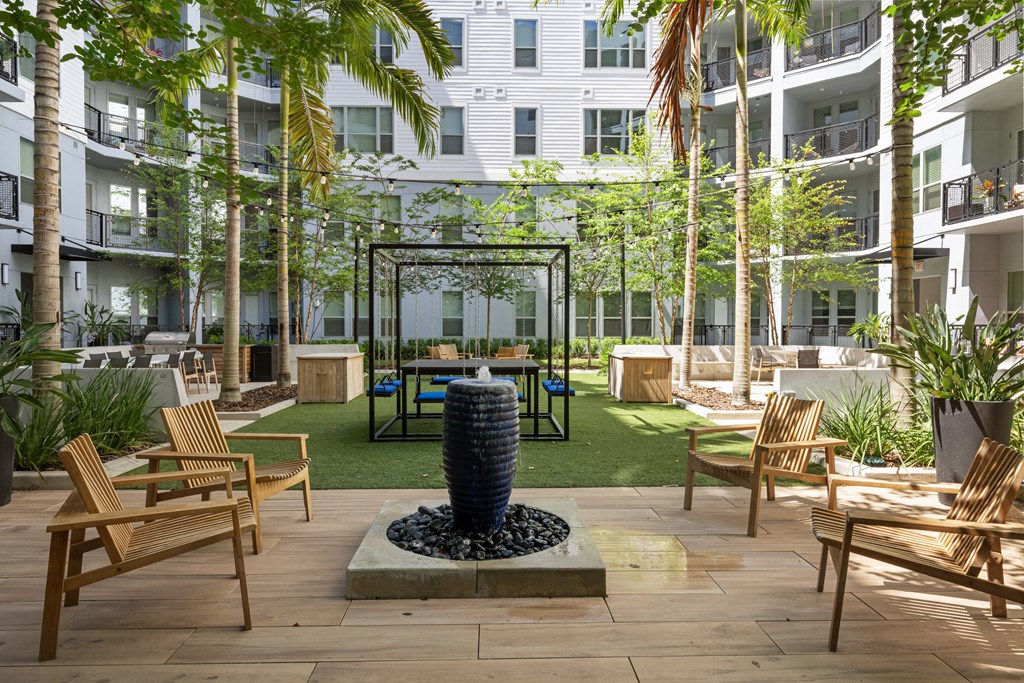 a courtyard with tables and chairs and a water fountain