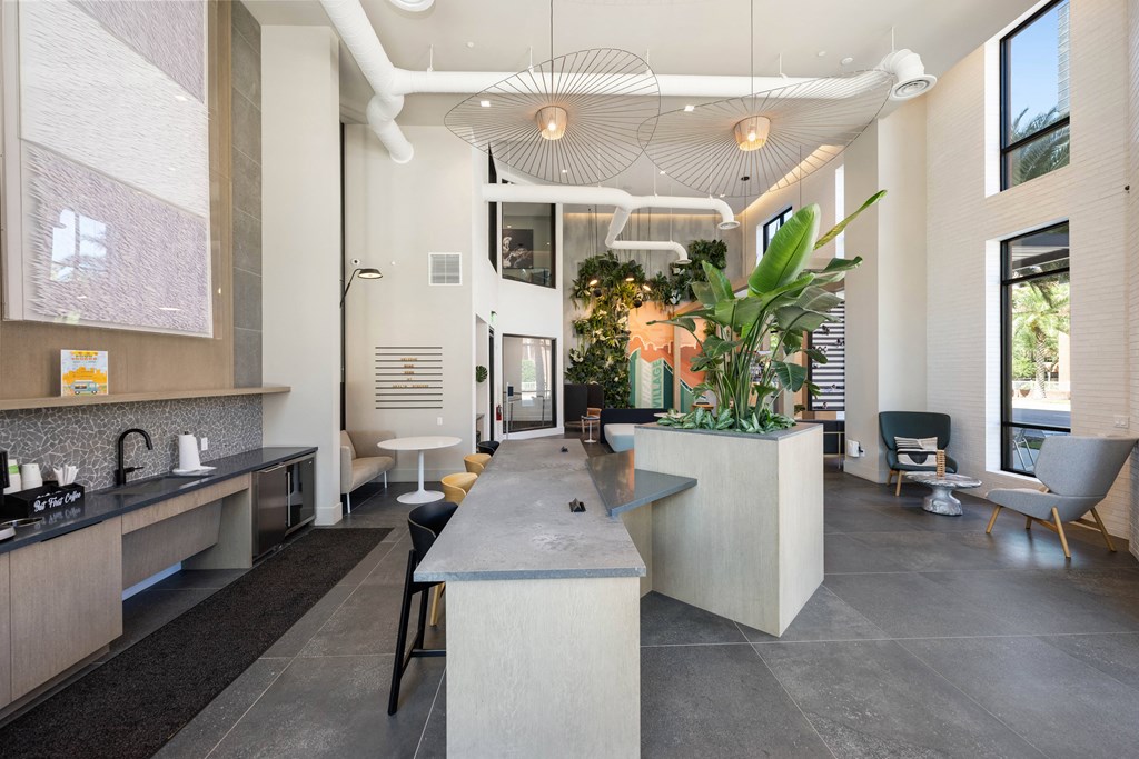 a large kitchen with a long counter and a living room with a table and chairs