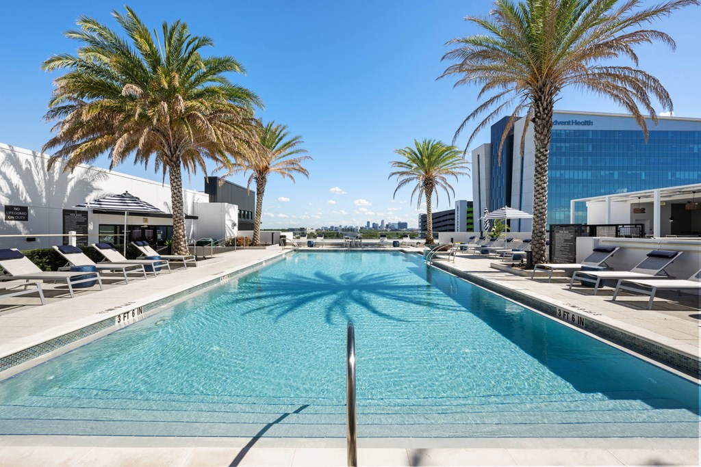 a swimming pool with palm trees in front of a building