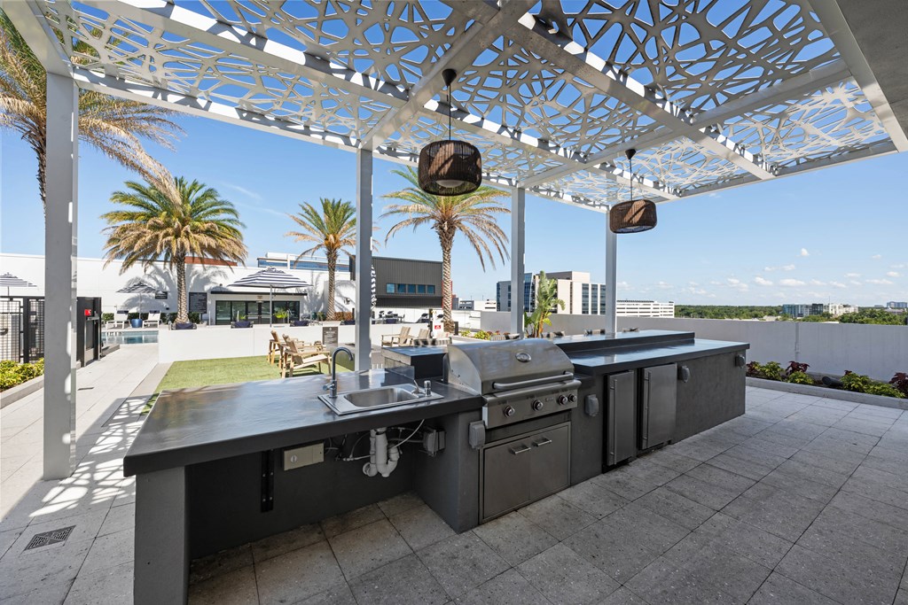 a stainless steel outdoor kitchen with a roof terrace and palm trees
