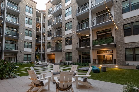 A large building with a patio and chairs in front.