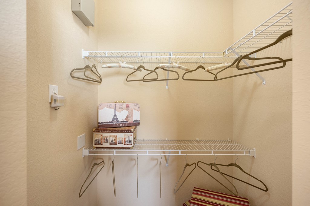 A walk in closet with shelving