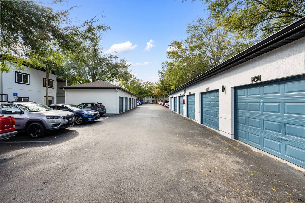 a city street with garages and parked cars
