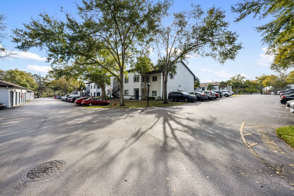 a street with cars parked in front of a white house