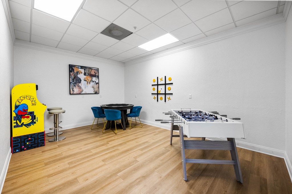 a room with a table with a giant chessboard and a game table and chairs