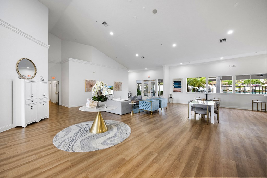 a living room with white walls and wooden floors and a table with a mirror