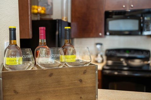 a box of wine glasses and bottles of wine on a kitchen counter