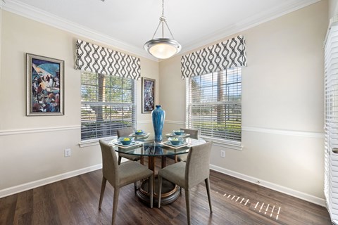a dining room with a glass table and chairs