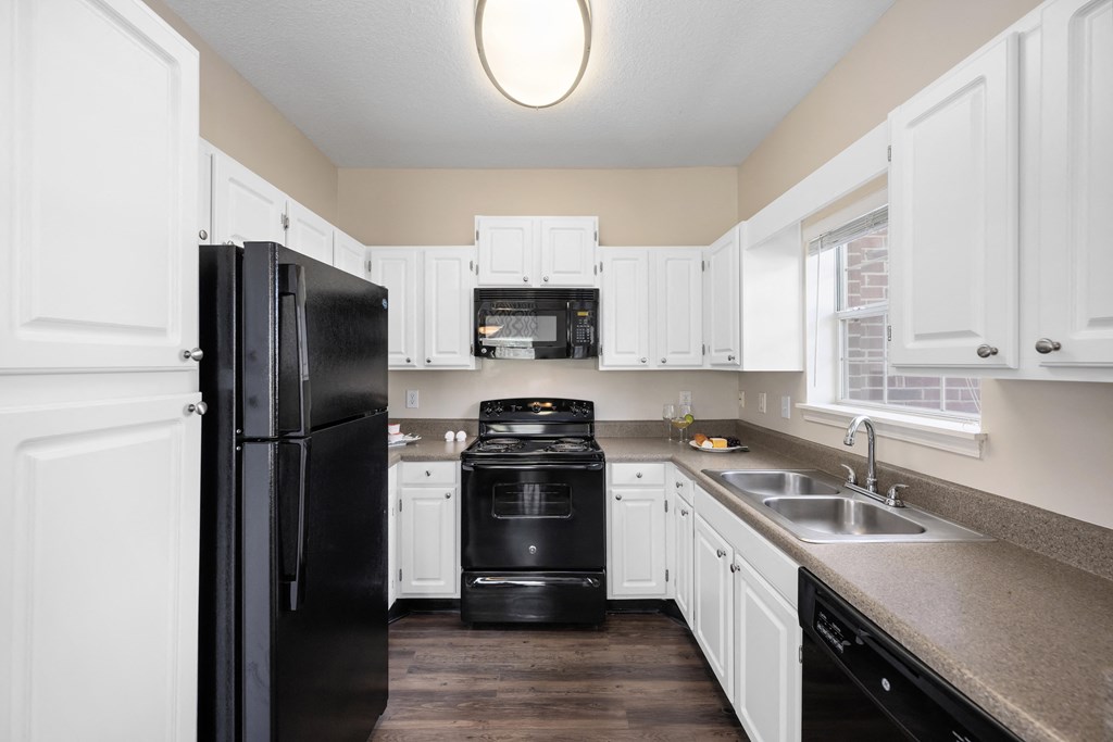 a kitchen with black appliances and white cabinets