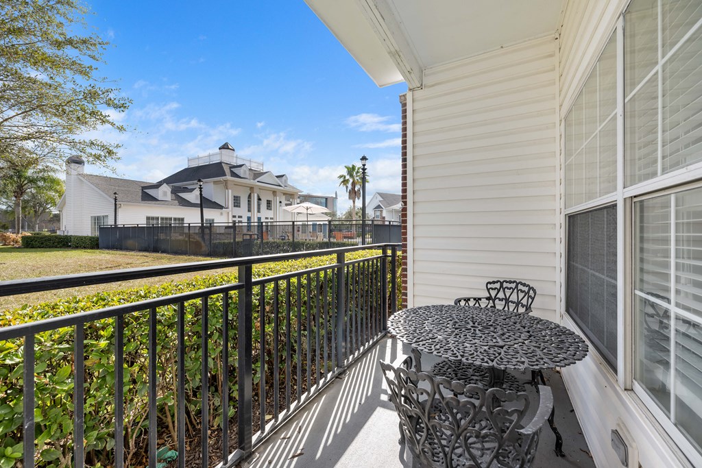 a small patio with a table and chairs on a balcony