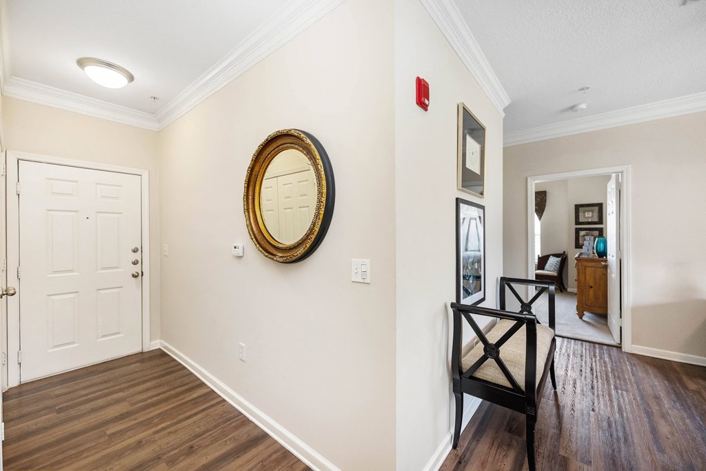 a hallway with a white door and a mirror on the wall