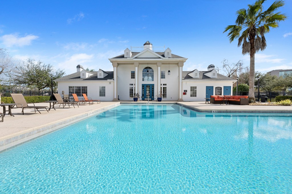 a large swimming pool in front of a white house