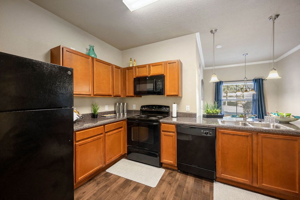 A kitchen with wooden cabinets and black appliances.