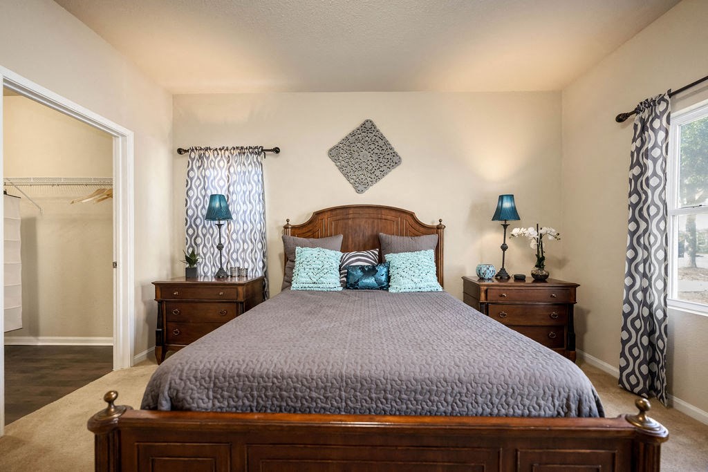 A bedroom with a large bed and a wooden headboard.