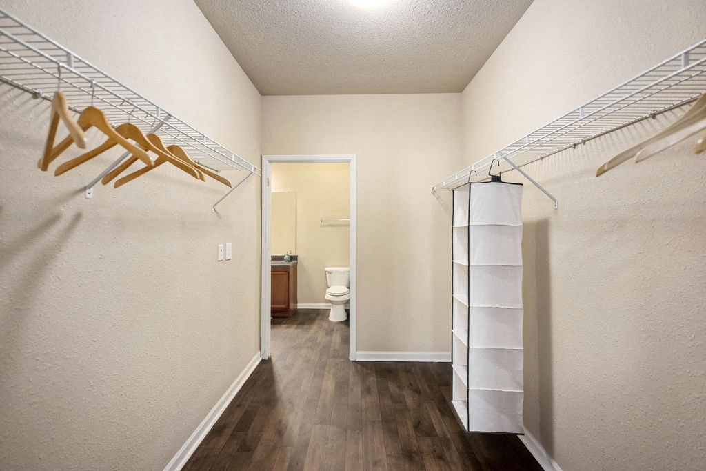 A hallway with a toilet and a white door.