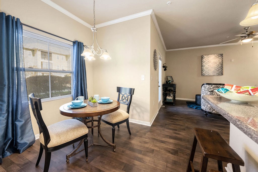 A dining room with a table set for two and a bar area in the background.