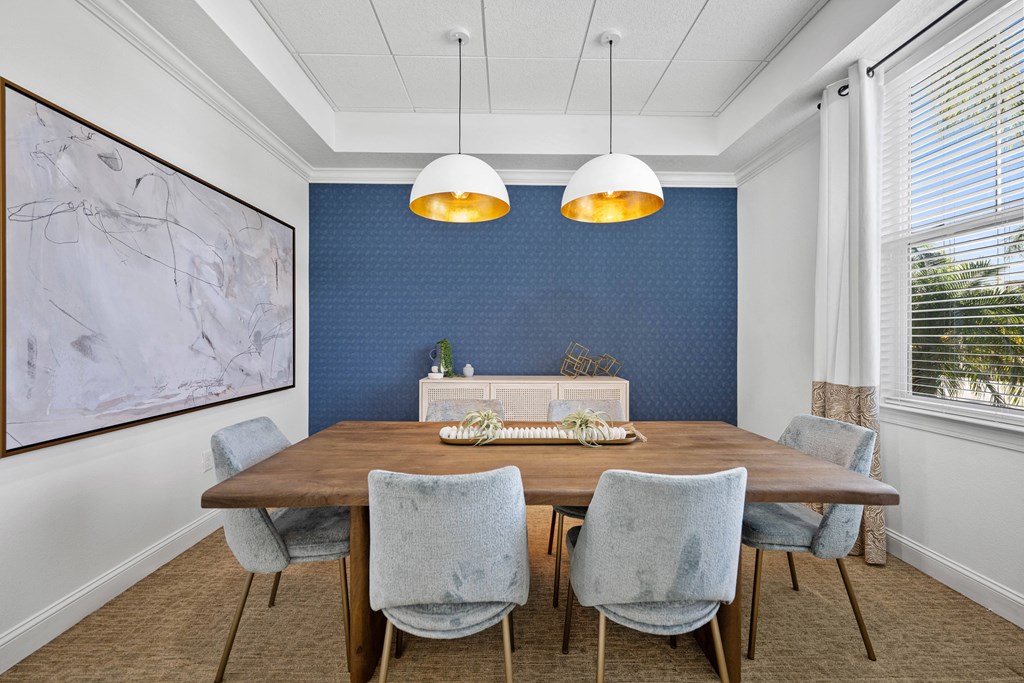 a dining room with blue wallpaper and a wooden table and chairs