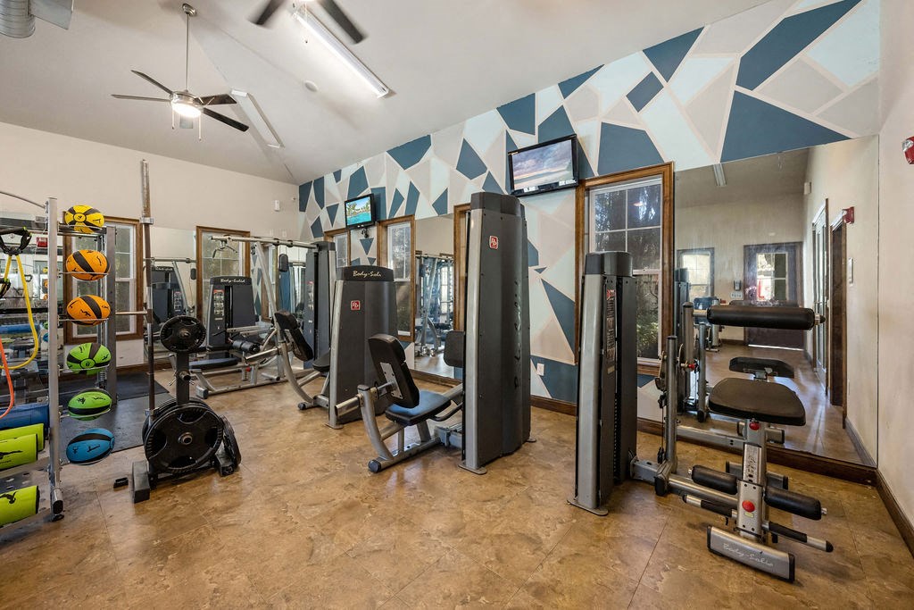 A gym with a variety of equipment including weights and machines.