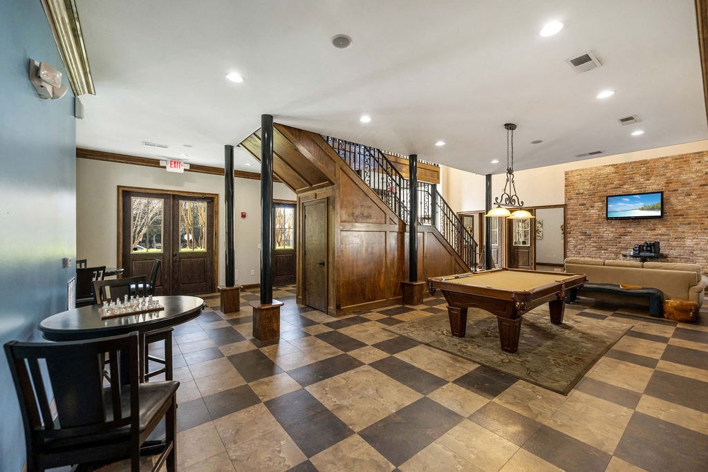 A living room with a checkered floor and a staircase.