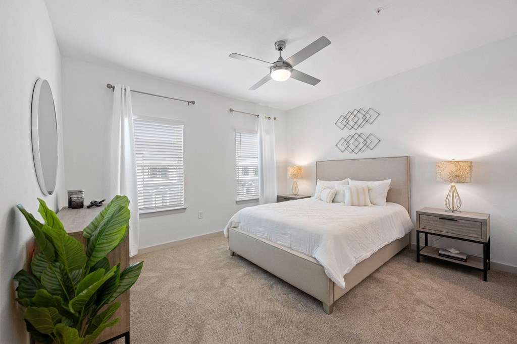 a bedroom with a large bed and a ceiling fan
