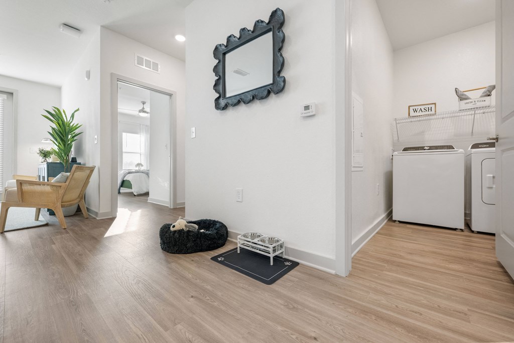 the living room and kitchen of a modern apartment with a washer and dryer