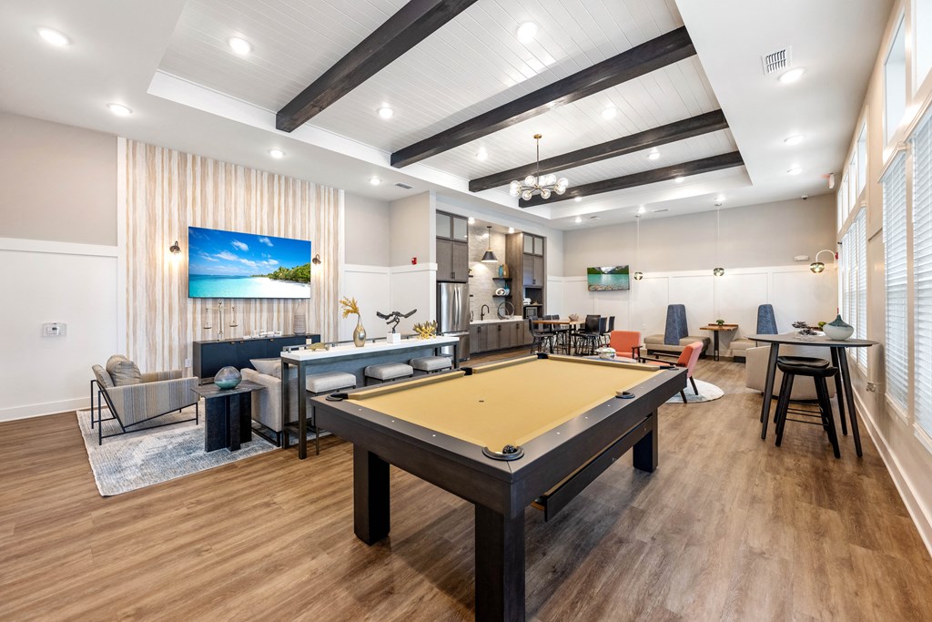 a community room with a pool table and couches