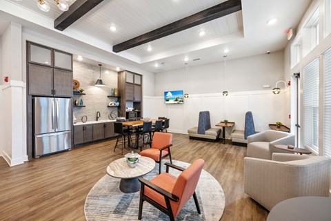 a living room with couches and chairs and a kitchen with a table