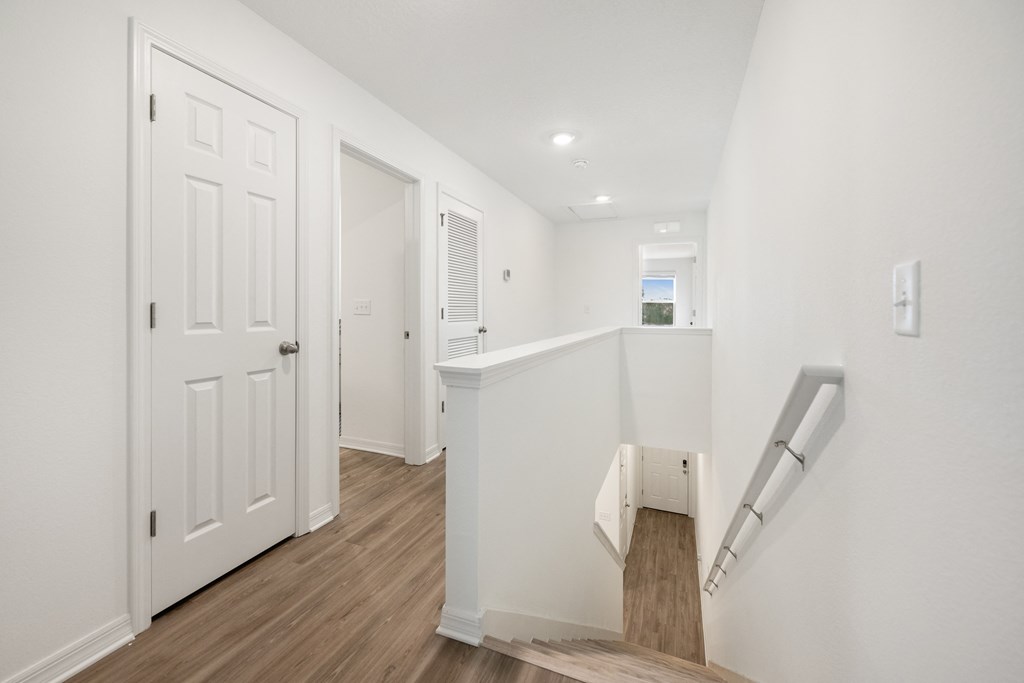 A white door is on the left and a staircase is on the right.