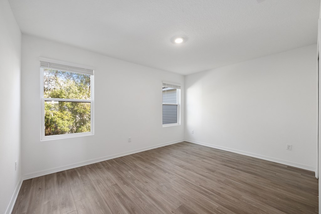 A room with a window and wooden flooring.