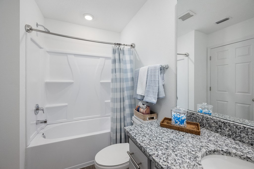 A bathroom with a white tub, toilet, and sink.