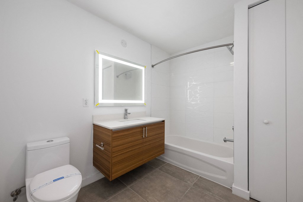 a bathroom with a white toilet next to a bathtub with a shower stall