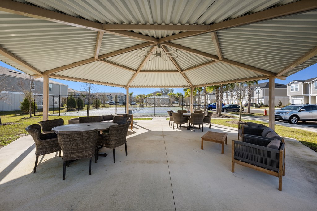 A patio with a table and chairs under a canopy.