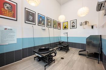 A room with a blue and white tiled wall and a sign that says "suds" on it.