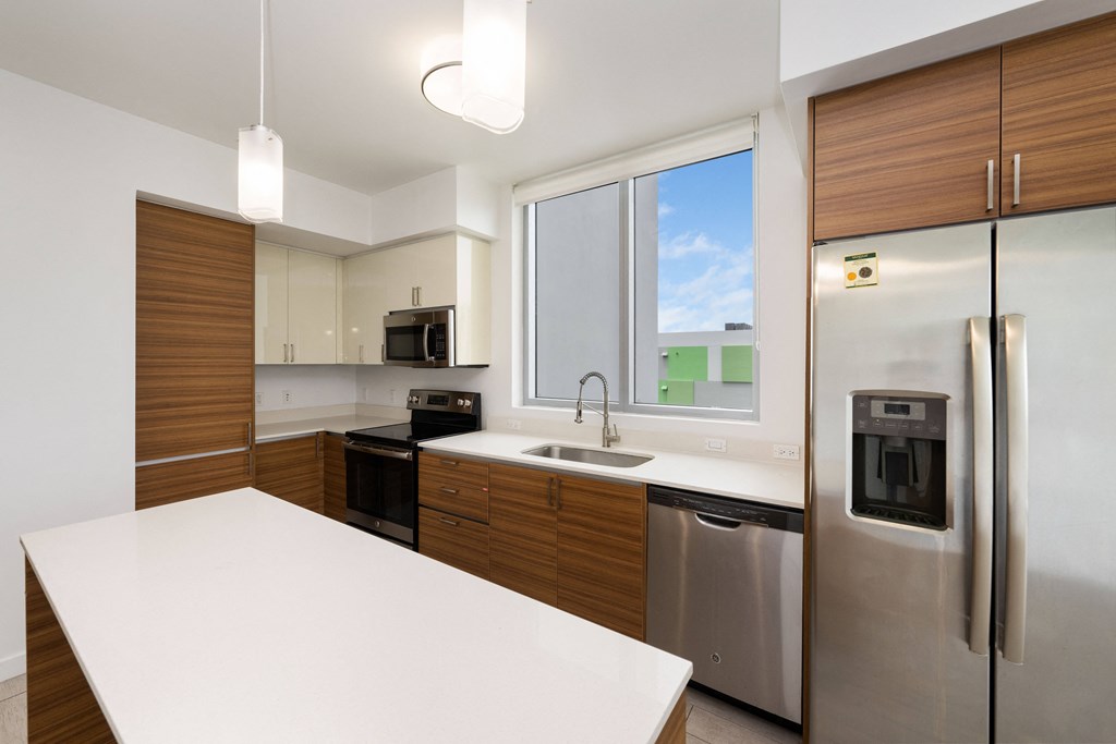 a kitchen with white countertops and wooden cabinets