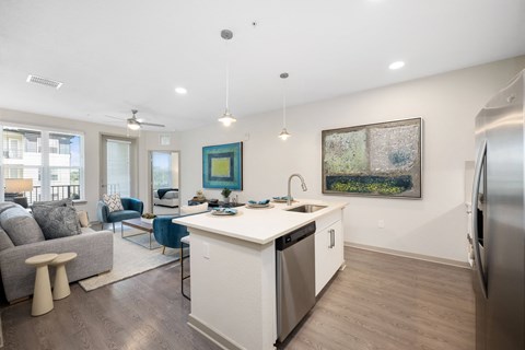 A kitchen with a white counter top and a painting hanging on the wall.