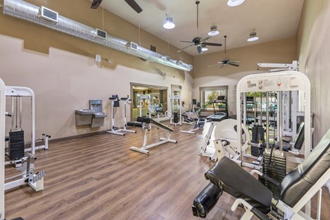 A gym with a variety of equipment including weights and machines.