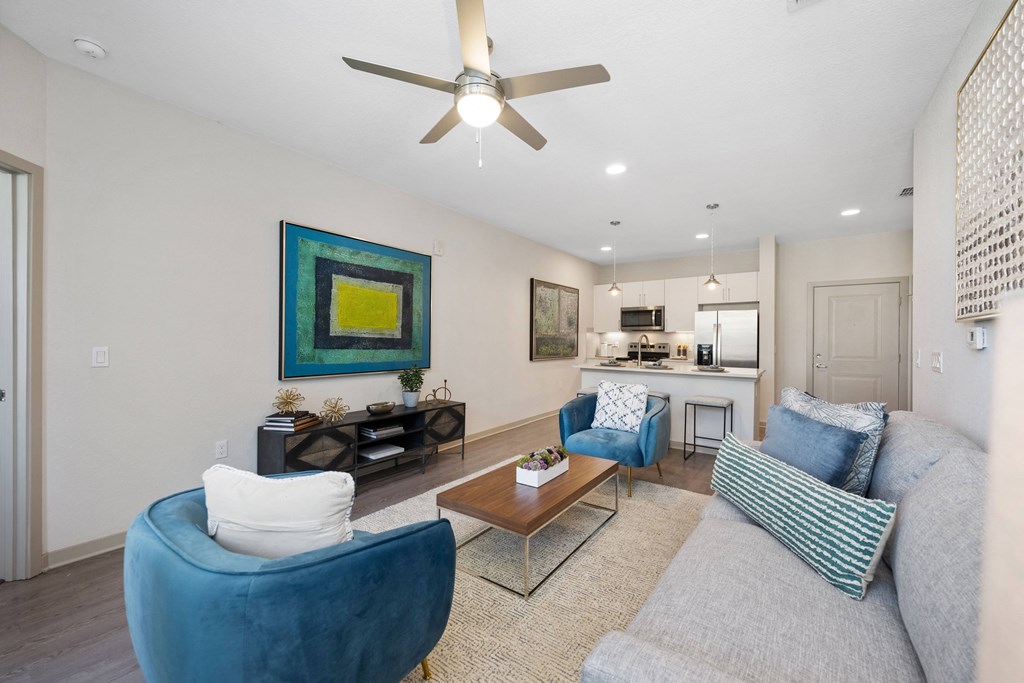 living room with a ceiling fan and couches