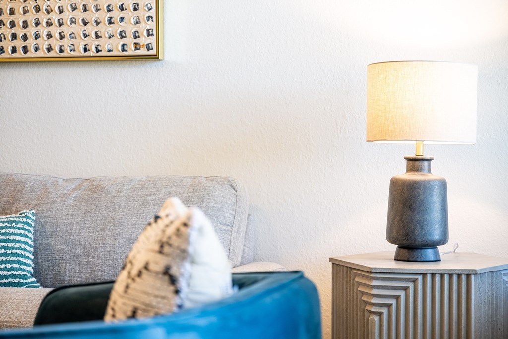 living room with a couch and a table with a lamp on it